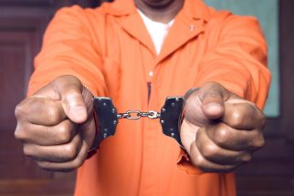 Image of a Man with Outstretch Hands - Handcuffed in Court